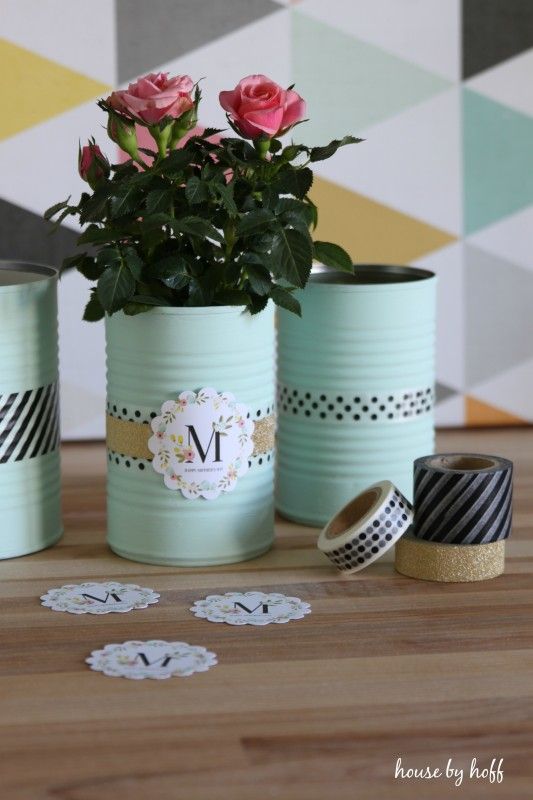 Painted tin cans is an elegant container for potted roses.