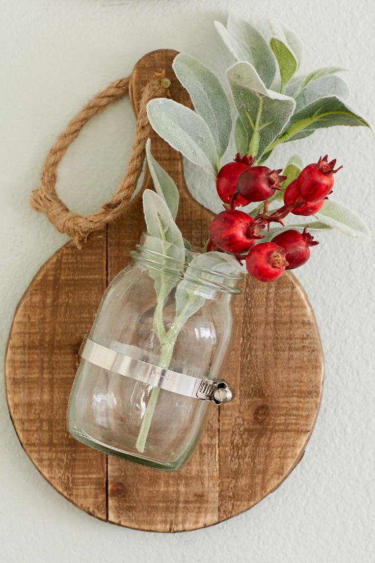 Breadboards with mason jars attached are a festive way to display holiday floral...
