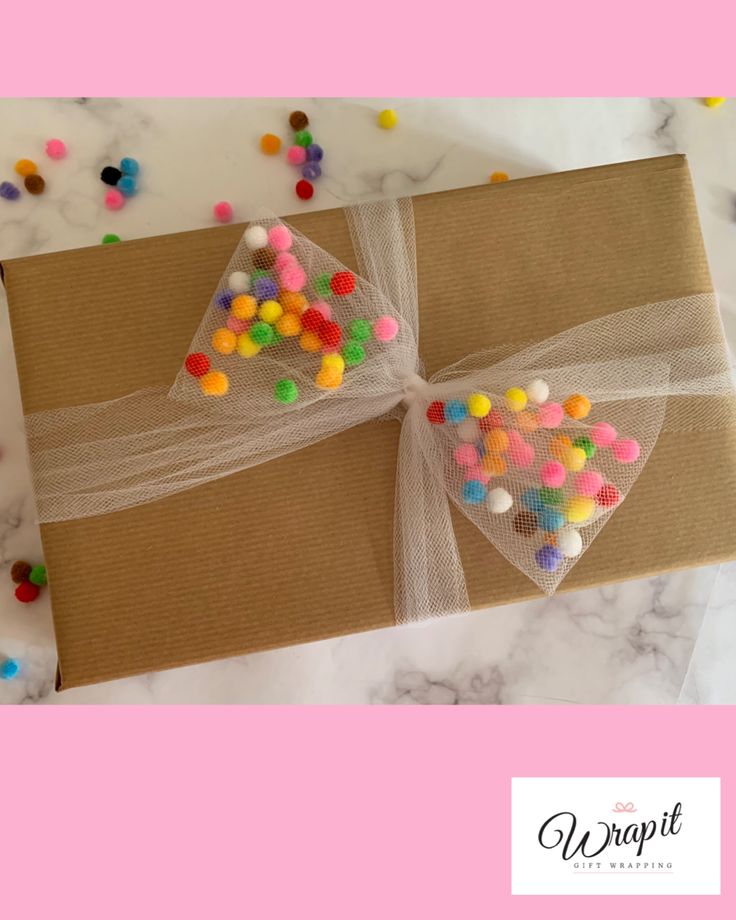 Tulle bow filled with mini pom poms, fun, colourful gift wrap for birthdays.
